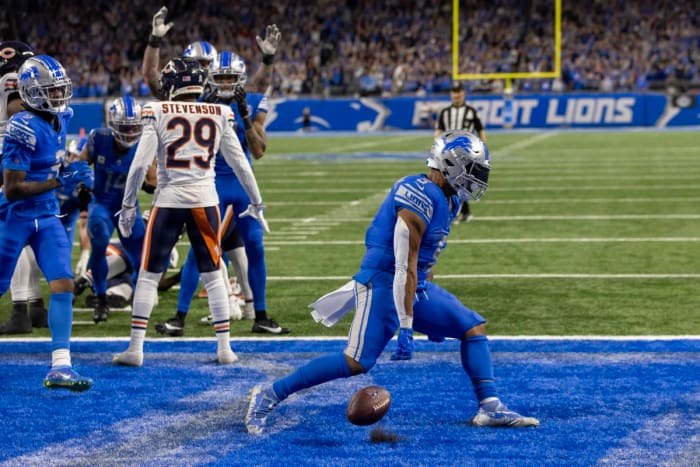 David Montgomery throws the ball down flexing his arms toward the ground celebrating in the endzone